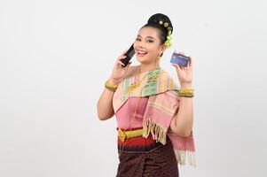 Young beautiful woman in northeastern dress use smartphone and credit card posture photo