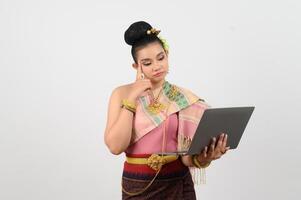 Young beautiful woman in northeastern dress holding laptop posting photo