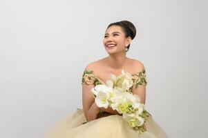 Young asian beautiful bride with orchid bouquet on white background photo