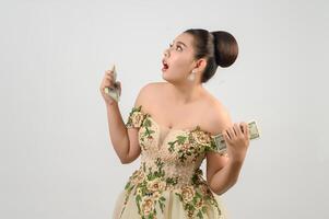 Young asian beautiful bride holding dollar bills in hand photo