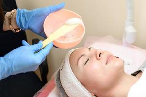 The process of applying a moisturizing mask to the face in a spa salon. photo