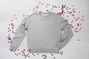 Grey sweatshirt mockup. Valentines Day concept shirt, b-day concept on wooden background. Copy space, template blank front view clothes. Romantic outfit. Flat lay birthday holiday fashion photo