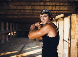 Muscular man with baseball bat photo