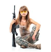 Soldier young beautyful girl dressed in a camouflage with a gun in his hand on white photo