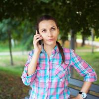 Portrait of a woman in a park talking on the phone photo