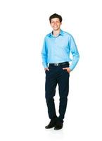 Happy young businessman standing with his hands in pockets on white photo