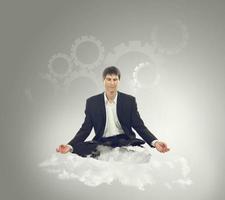 Businessman sitting in lotus position on a cloud photo