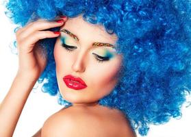 Portrait of a young beautiful girl with bright makeup in blue wig photo