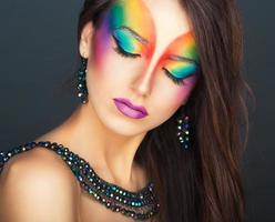 Portrait of a young beautiful girl with a fashion bright multicolored makeup photo