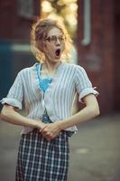 Funny crazy girl student in glasses and a vintage dress photo