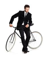 Attractive man in a classic suit with a bicycle on a white photo