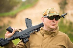 Man in camouflage with a shotgun photo