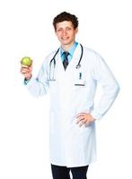 Portrait of a smiling male doctor holding green apple on white photo