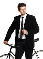 Attractive man in a classic suit with a bicycle on a white photo