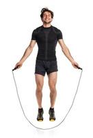 Athletic attractive man jumping on a rope on the white photo