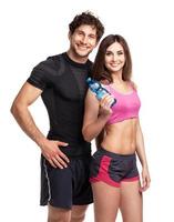Athletic man and woman with bottle of water on the white photo