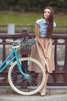 joven mujer hermosa, elegantemente vestida con bicicleta foto