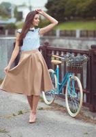 joven mujer hermosa, elegantemente vestida con bicicleta foto