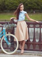 joven mujer hermosa, elegantemente vestida con bicicleta foto