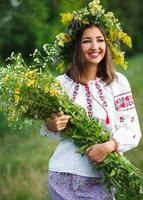 Young beautiful smiling girl in Ukrainian costume with a wreath on his head photo