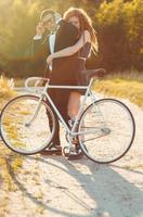 Young stylish guy with girl and the bicycle outdoors photo