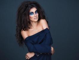 Portrait of a young girl with a fashion dark  makeup of eyes and and bulk hair photo