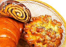 Fresh and tasty buns with with sesame and poppy seeds, bagel with jam and roll with chocolate in a basket photo