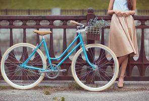 joven mujer hermosa, elegantemente vestida con bicicleta foto