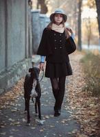 Young attractive girl dressed elegantly walks with the dog greyhound photo