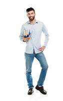 Young bearded smiling man with books in hands on white photo