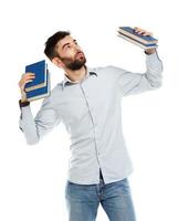 Young bearded smiling man with books in hand on white photo