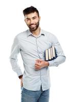 joven barbado sonriente hombre con libros en mano en blanco foto