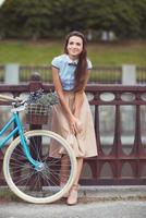 Young beautiful, elegantly dressed woman with bicycle photo