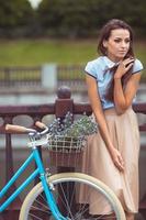 joven mujer hermosa, elegantemente vestida con bicicleta foto