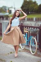 Young beautiful, elegantly dressed woman with bicycle photo