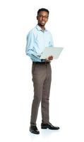 Happy african american college student standing with laptop on white photo