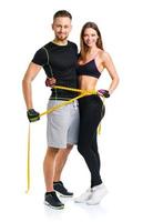 Happy athletic couple - man and woman with measuring tape on the white photo