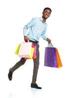 Happy african american man holding shopping bags on white background photo