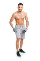 hombre atlético con pesas en el blanco foto