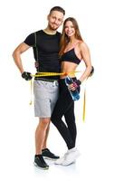 Happy athletic couple - man and woman with measuring tape on the white photo