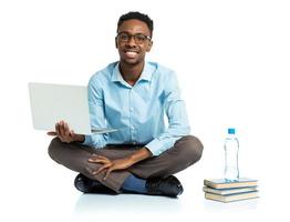 Happy african american college student sitting with laptop on white photo