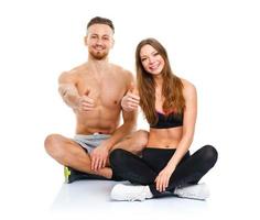 Athletic man and woman after fitness exercise with a finger up on the white photo