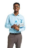 Happy african american college student standing with books in his hands on white photo