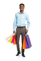 Happy african american man holding shopping bags on white background photo