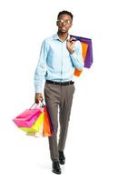 Happy african american man holding shopping bags on white background photo