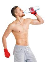 deporte atractivo hombre vistiendo boxeo vendajes con botella de agua en el blanco foto