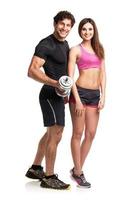 Athletic couple - man and woman with dumbbells on the white photo