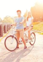 joven hombre y mujer montando un bicicleta en el parque al aire libre foto