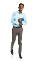 Happy african american college student with books in his hands  standing on white photo