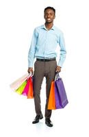 Happy african american man holding shopping bags on white background photo